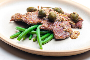 pork steak with mustard sauce with capers served with green beans