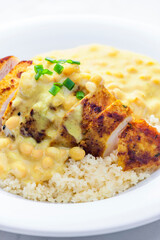 chicken breast served with creamy curry chickpea sauce and couscous