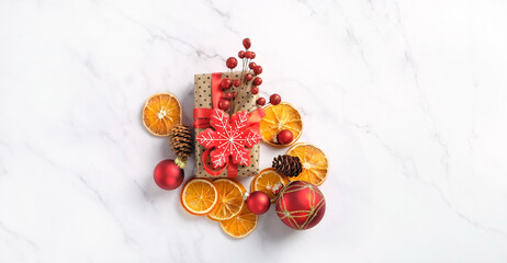 Christmas decorations, gift box and dried citrus slices on marble table. Christmas holiday background. festive winter season concept. minimal style. flat lay. copy space