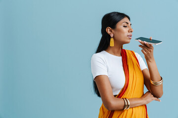 Young beautiful indian woman in traditional dress talking phone