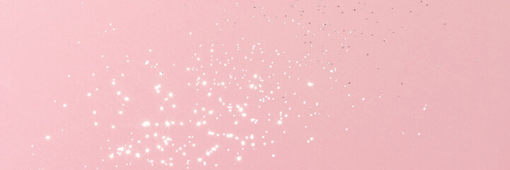 Sparkling silver glitter on pink background banner texture. Abstract holiday blurred lights header....