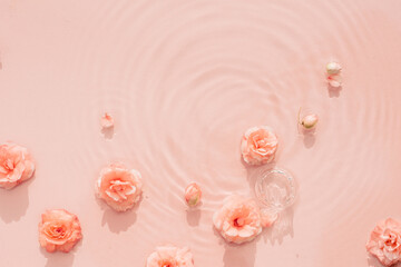 Pink aquatic, transparent water texture with ripples and drops and pink flowers. Water background