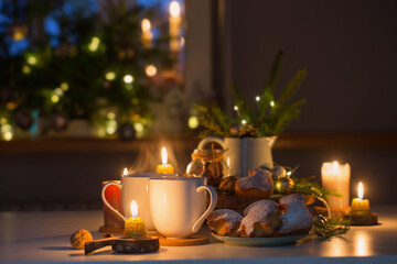 two cups of tea with homemade christmas baked goods on kitchen with christmas decoration