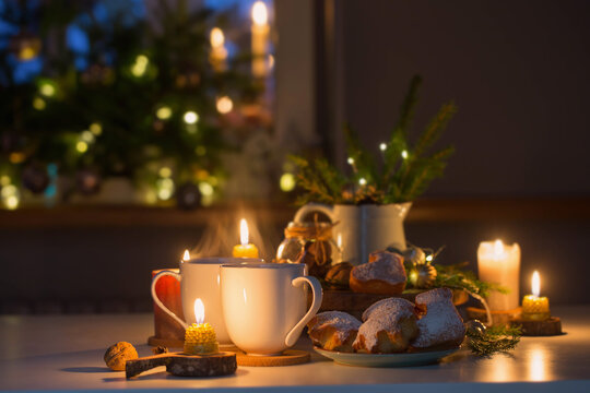two cups of tea with homemade christmas baked goods on kitchen with christmas decoration