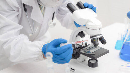 men in a laboratory microscope with microscope slide in hand