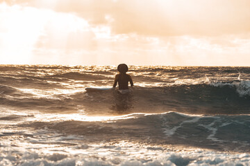 surf girl in the water during a beautiful sunset
