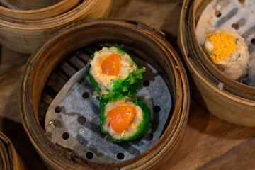Chinese Dimsum in bamboo basket.steamed dumpling dimsum in traditional bamboo steamer on wooden background