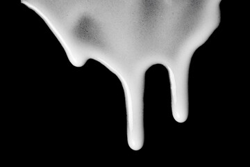 Streaks of white cream on a black background.