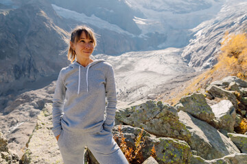Naklejka premium Portrait of smiling woman in the mountains. Mountains with glacier and tourist girl