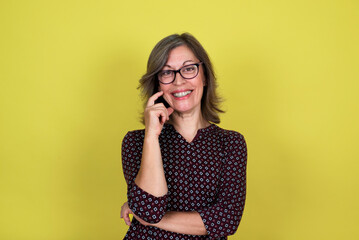 Portrait of a smiling middle-aged woman on a yellow background
