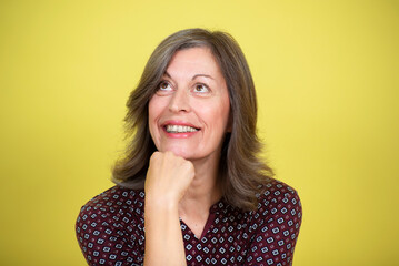 Fototapeta na wymiar Portrait of a smiling middle-aged woman on a yellow background 