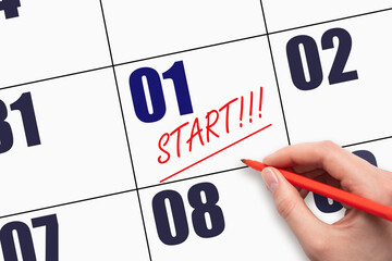 1st day of the month. Hand writing text START and drawing a line on calendar date.