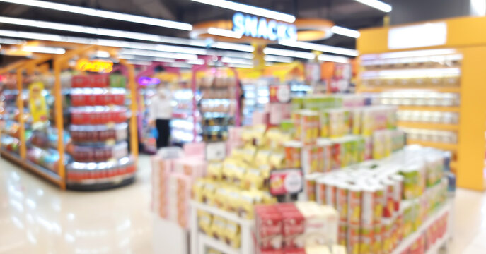 blurred view of various local and imported brands of flavoured chips and snacks displayed on store shelf use as background for merchandise or consumption concept. products showing in supermarket.