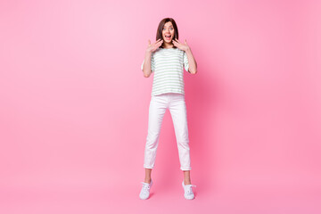 Full size photo of nice lovely girl wear striped t-shirt white pants sneakers impressed staring at sale isolated on pink color background