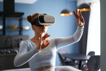 Woman in virtual reality goggles enters metaverse, controls immersive experience with hand gestures...