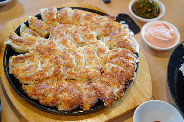 selective focus, close up Japanese dumplings is called Gyoza or Jiaozi in China, gyoza with pork meat and vegetables on black plate, dumplings snack with soy sauce.