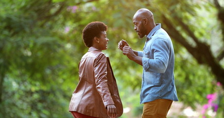 Happy African couple dancing celebrating outside in street. two people dance