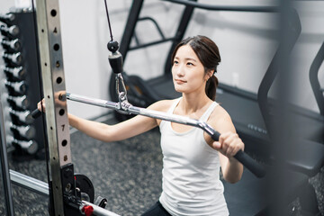 ジムでトレーニングする若い女性