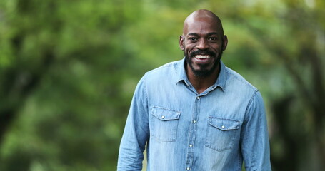 Happy African man smiling outside. Joyful black ethnicity person standing