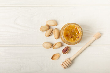 Nut honey jar on white wood. Cold medicine. Useful fortified product with almonds, pistachios, star anise and cinnamon for health and beauty. Vegetarian diet organic product. Copy space.place for text