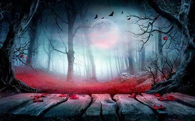 Fototapeten Halloween - Holztisch im gruseligen Wald bei Nacht mit roten Blättern in der Herbstlandschaft bei Mondschein © Romolo Tavani