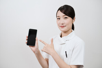 スマートフォンを操作する白衣の女性
