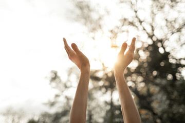 Fototapeta Hands reaching out to sky, warm sunshine in the palm of hands Worship and praise symbol  obraz