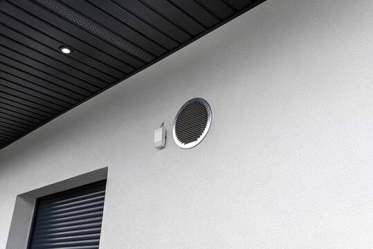 Air intake and exhaust in the wall of a single family house for mechanical ventilation with heat recovery, secured with a metal grill with mesh.