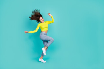 Full size portrait of pretty positive girl dancing stand one leg flying hair isolated on teal color background