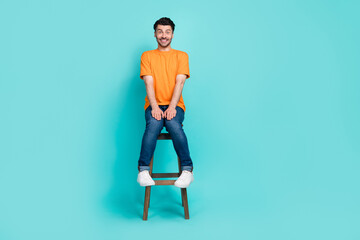 Full length photo of nice positive man wear fashionable trendy clothes sit chair wait manicure procedure isolated on cyan color background