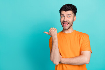 Photo of young handsome bearded funny positive guy smile excited finger pointing empty space advertisement crazy isolated on aquamarine color background