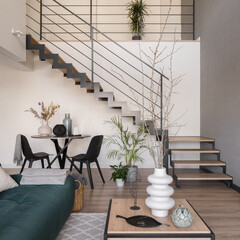 Modern staircase in living room with table