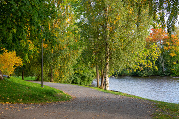 Autumnal park in Finland. An image of a beautiful park on an autumn evening, sun is about to go down and colorful trees and paths in fresh air invites people to walk.