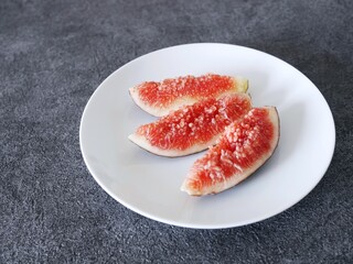 くし切りした熟したいちじくと白い皿