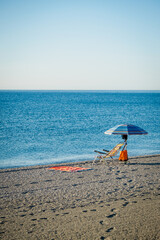 Empty chair with parasol on sandy beach in Spain