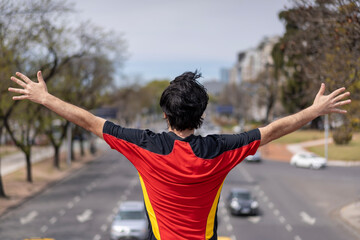 Fototapeta na wymiar Successful man raising arms after running. Fitness male athlete with arms up celebrating success and goals after sport exercising .