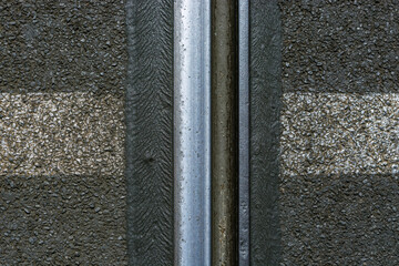 Fragment of a steel rail of a tram track on a background of gray asphalt.