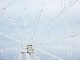 Fototapeta premium Fragment of ferris wheel under construction on a background of gray cloudy sky