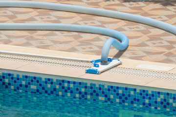 Swimming pool bottom cleaner prepared for use, on a sunny day
