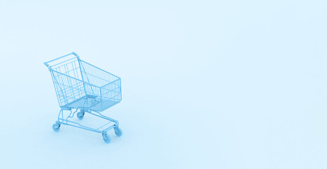 Pastel blue shopping cart on blue background. Black Friday sales minimalistic concept. Shop online, free delivery, Cybermonday, Discounts, St. Valentines and International Women's Day