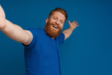 Naklejka premium Ginger white man with beard gesturing while taking selfie photo