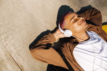Portrait of young handsome ralaxed smiling boy in headphones