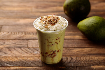 avocado special cocktail smoothie with raw fruit served in glass side view on wooden table morning meal