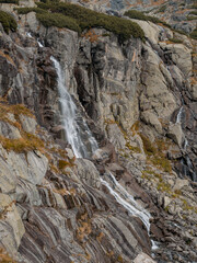 Fototapeta na wymiar A natural waterfall by a hiking trail in the Tatras in Slovakia