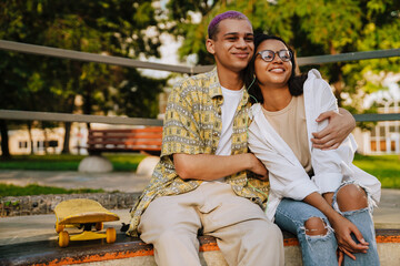 Young handsome stylish smiling boy hugging beautiful girl in glasses