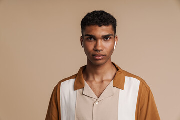 Obraz premium Portrait of young handsome calm african man in wireless headphones