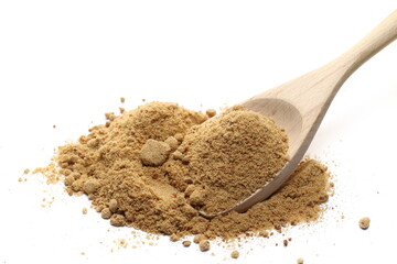 Unrefined cane sugar pile in wooden spoon isolated on white