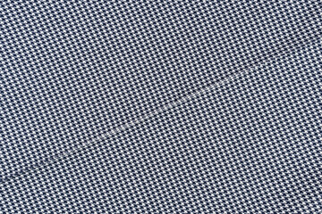 Black and white fabric with houndstooth pattern and seam.