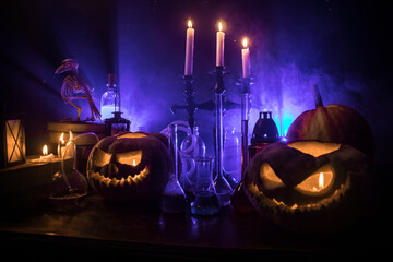 Halloween still-life background with different elements on dark toned foggy background. Selective...