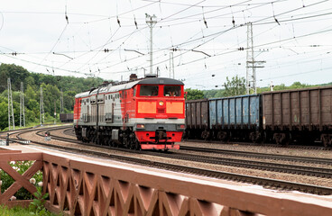 Obraz premium electric train rides on rails at a small railway station